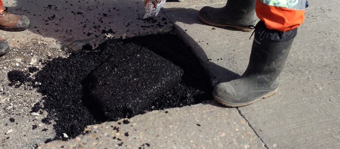 How do I apply EZ Street cold asphalt to a pothole filled with water?